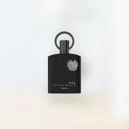 Trio Fragrance Afnan Supremacy Noir black perfume bottle with silver emblem and ring cap. Notes of bergamot, fir, violet, leather, lavender, pine, patchouli, and labdanum.